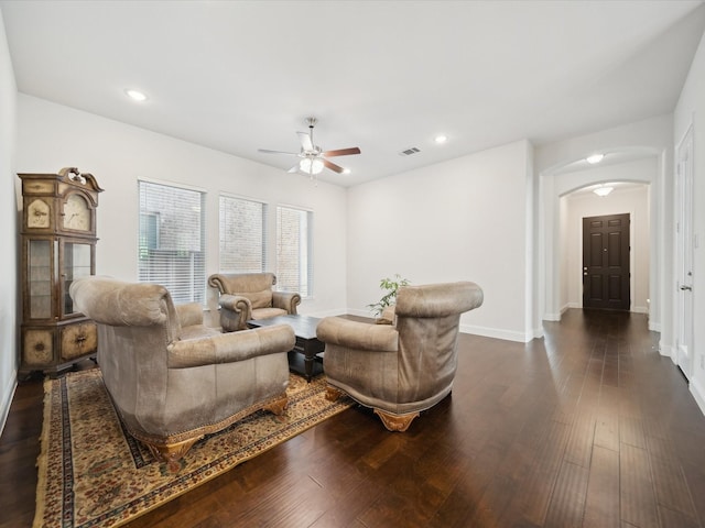 living room featuring ceiling fan and dark hardwood / wood-style flooring