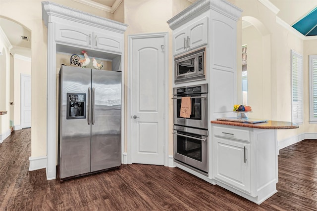 kitchen with stainless steel appliances, dark hardwood / wood-style flooring, white cabinetry, and ornamental molding