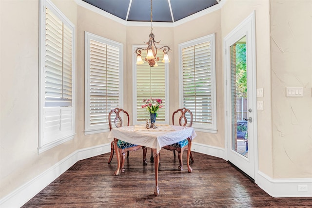 dining area with dark hardwood / wood-style flooring, crown molding, and a chandelier