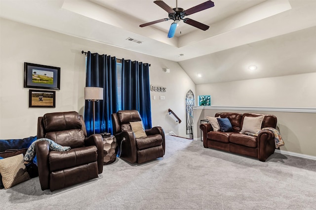 living room featuring a raised ceiling, light carpet, and ceiling fan