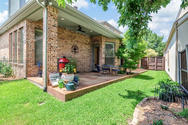 back of house with ceiling fan, a patio area, and a yard