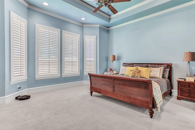 carpeted bedroom with ceiling fan, ornamental molding, and a tray ceiling