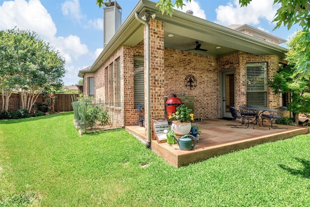 back of house with ceiling fan, a lawn, and a patio