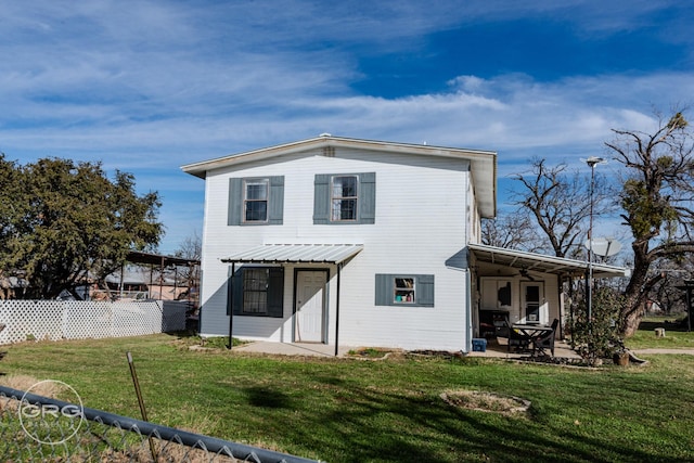 back of house featuring a patio area and a lawn