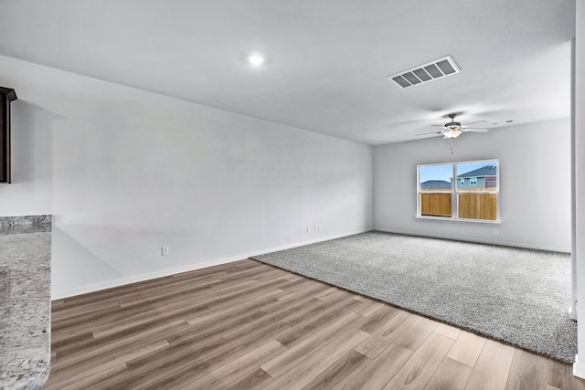 unfurnished living room featuring ceiling fan and hardwood / wood-style flooring