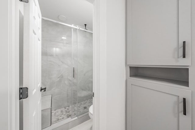 bathroom with an enclosed shower and toilet