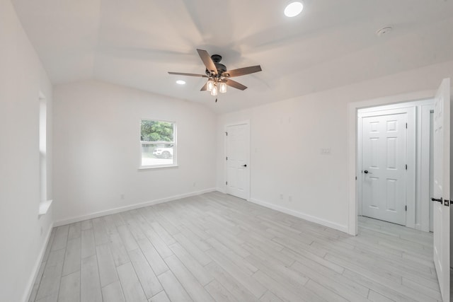 empty room featuring ceiling fan, light hardwood / wood-style flooring, and lofted ceiling