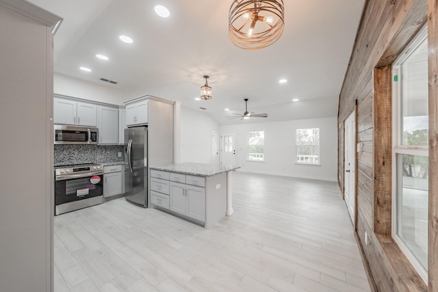 kitchen featuring ceiling fan, pendant lighting, stainless steel appliances, and tasteful backsplash