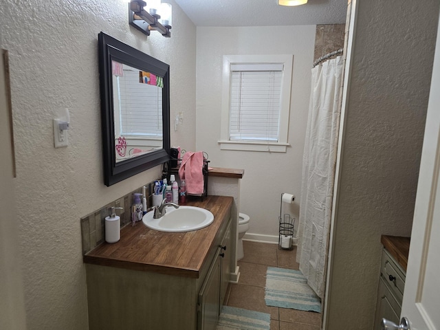 bathroom with toilet, tile patterned floors, and vanity