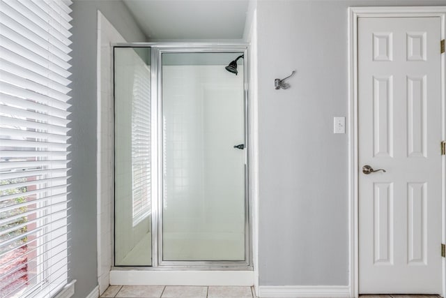 bathroom with an enclosed shower and tile patterned floors