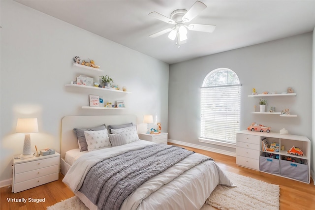 bedroom featuring light wood-type flooring, ceiling fan, and multiple windows