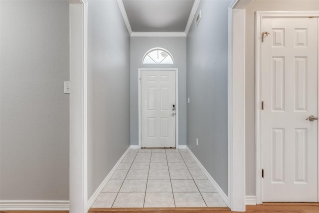 entryway with light tile patterned floors and crown molding