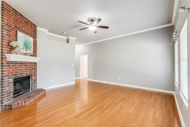 unfurnished living room with ceiling fan, light wood-type flooring, a fireplace, and crown molding