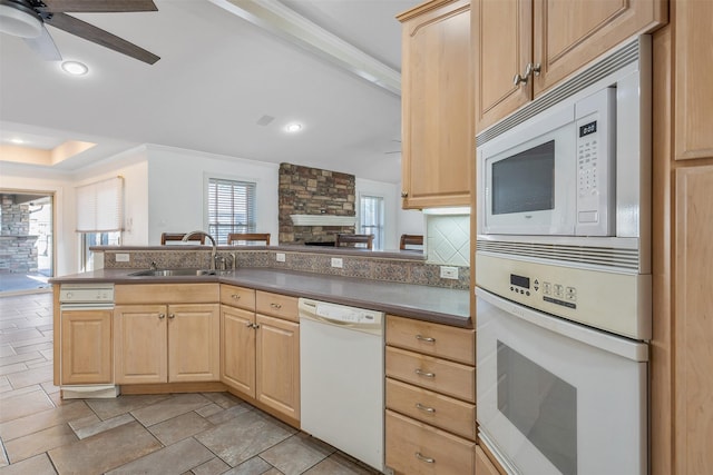 kitchen featuring kitchen peninsula, decorative backsplash, white appliances, light brown cabinetry, and sink