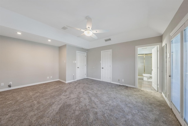 unfurnished bedroom with ceiling fan, ensuite bathroom, and light carpet