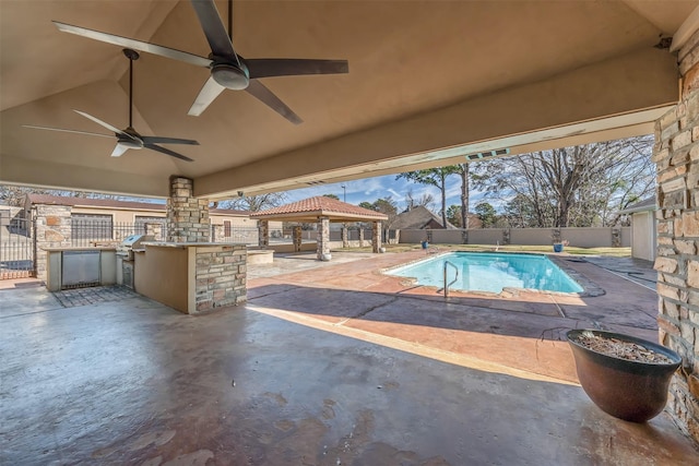 view of swimming pool with exterior kitchen, a gazebo, an outdoor bar, a patio, and ceiling fan