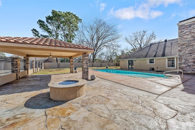 view of patio / terrace featuring an outdoor fire pit and a fenced in pool