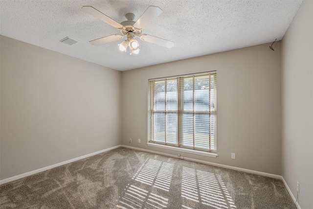 carpeted empty room featuring ceiling fan and a textured ceiling