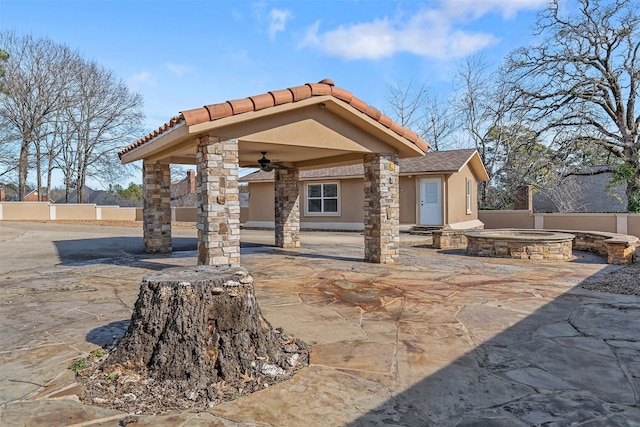 view of patio featuring ceiling fan, a gazebo, and an outdoor hot tub