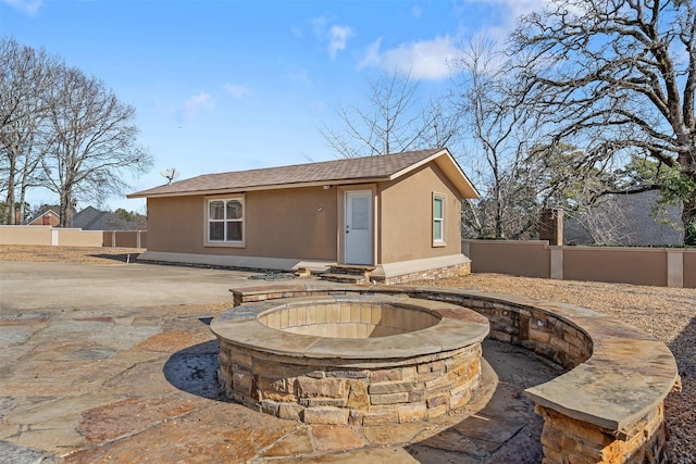 rear view of property with an outdoor fire pit and a patio