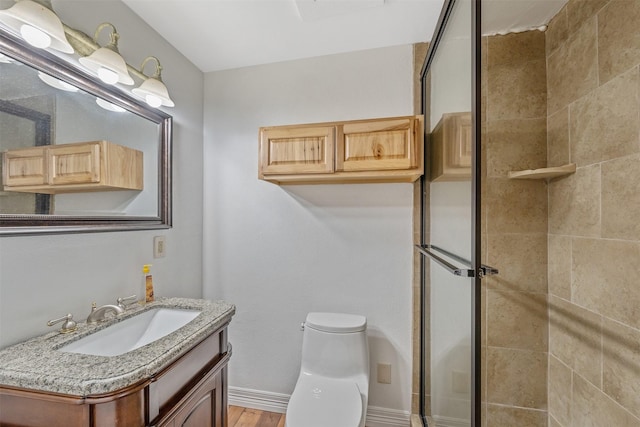 bathroom with toilet, vanity, a shower with door, and hardwood / wood-style flooring