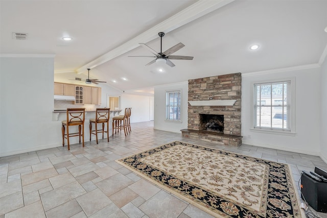 living room with ceiling fan, lofted ceiling with beams, a fireplace, and crown molding