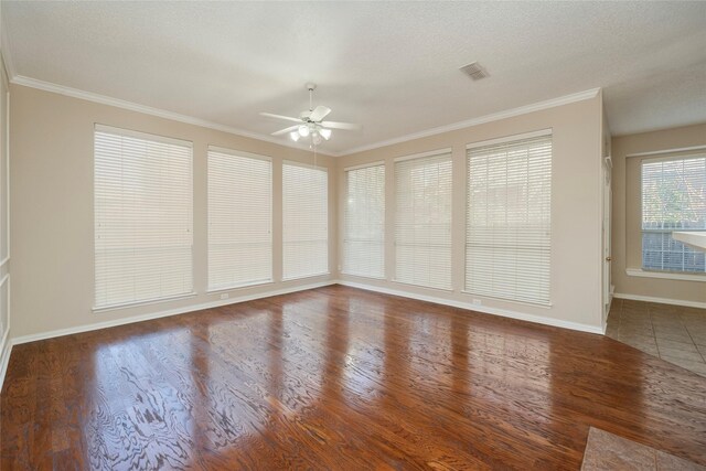 empty room with ceiling fan, plenty of natural light, and ornamental molding