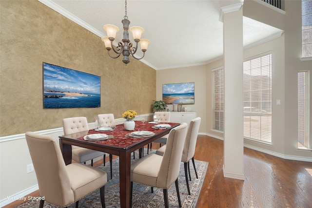 dining area with a chandelier, crown molding, baseboards, and wood finished floors