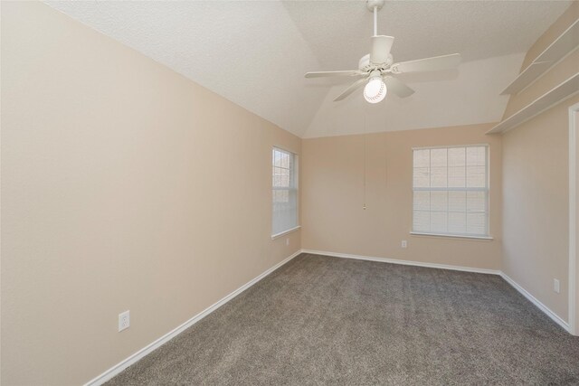 carpeted empty room with ceiling fan, vaulted ceiling, and a textured ceiling