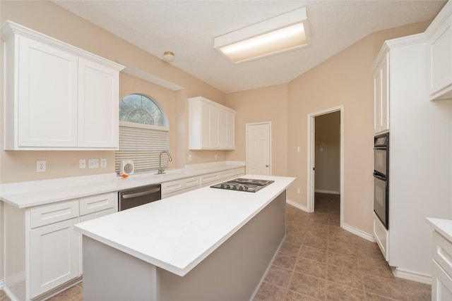 kitchen featuring sink, white cabinets, black appliances, and a center island