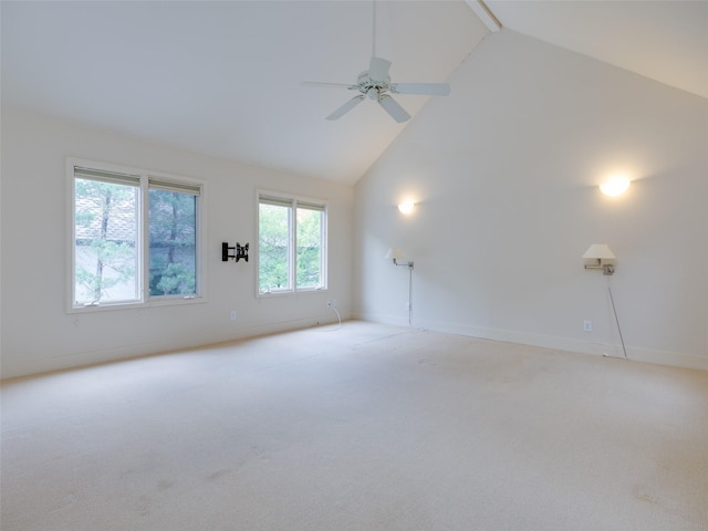 empty room featuring ceiling fan, light colored carpet, and high vaulted ceiling