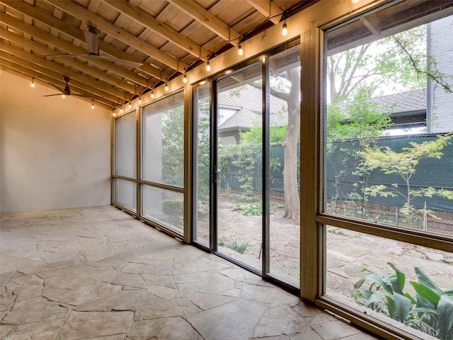 unfurnished sunroom with ceiling fan, wooden ceiling, and vaulted ceiling with beams