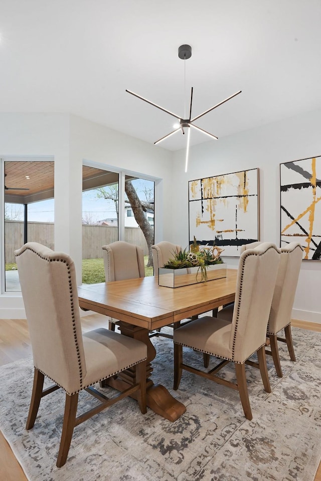 dining space with light wood-type flooring and an inviting chandelier