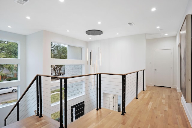 corridor featuring light wood-type flooring and plenty of natural light