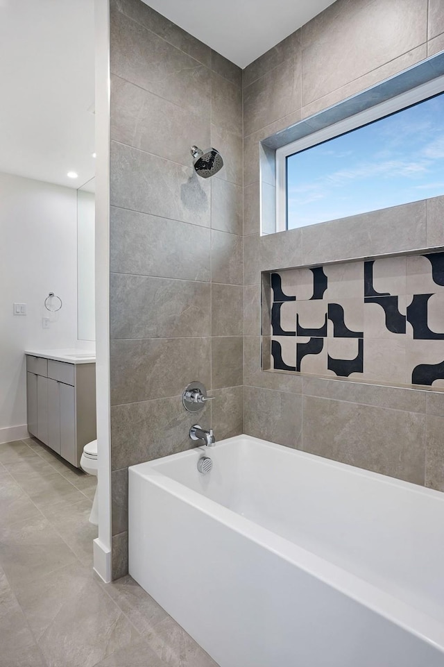 full bathroom featuring toilet, vanity, tiled shower / bath combo, and tile patterned floors