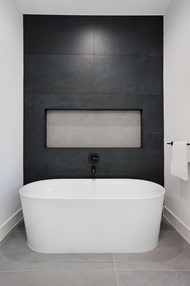 bathroom featuring tile patterned floors and a tub to relax in