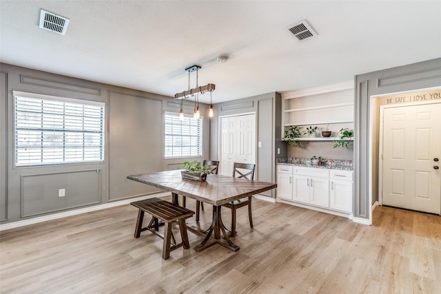 dining space featuring light hardwood / wood-style floors and built in features