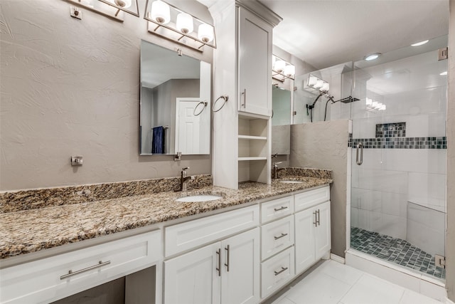 bathroom with tile patterned floors, a shower with shower door, and vanity