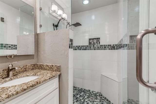 bathroom with vanity and a tile shower