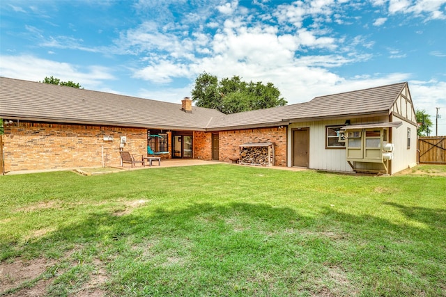 rear view of property with a patio area and a lawn