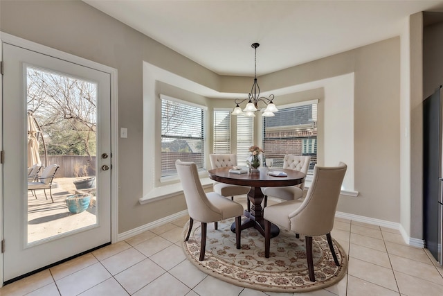 dining area with light tile patterned floors and a chandelier