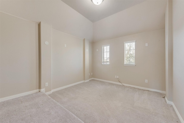 carpeted empty room with lofted ceiling