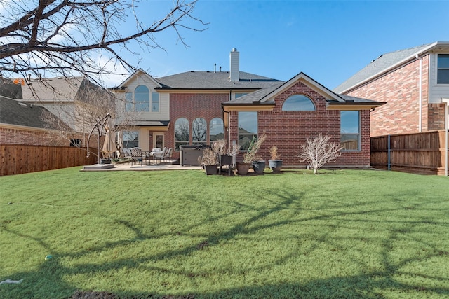 rear view of house with a hot tub, a lawn, and a patio