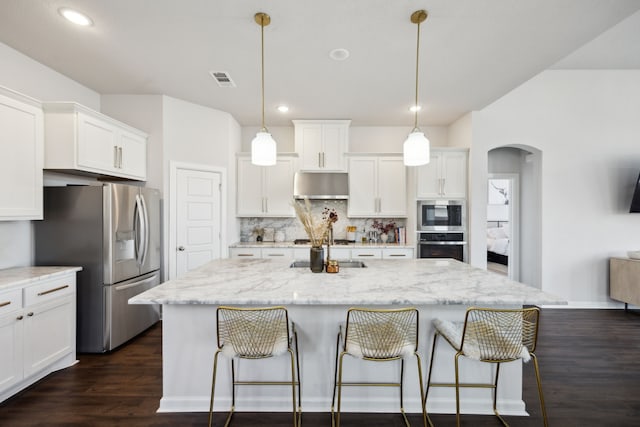 kitchen with stainless steel appliances and a center island with sink