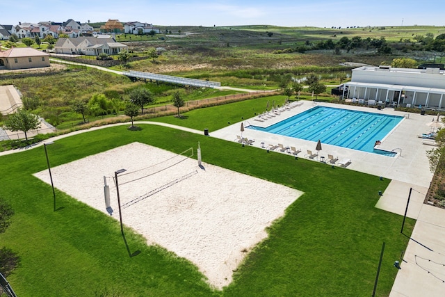 view of swimming pool featuring a lawn and volleyball court