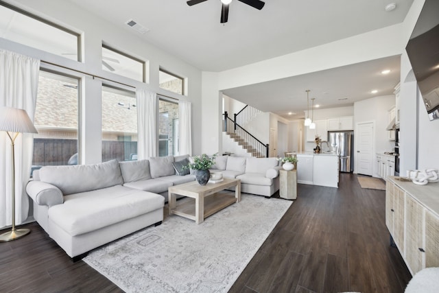 living room featuring ceiling fan and dark hardwood / wood-style flooring