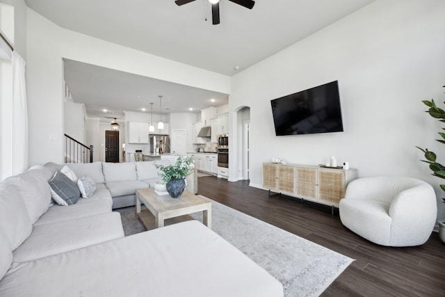 living room with ceiling fan and dark hardwood / wood-style flooring