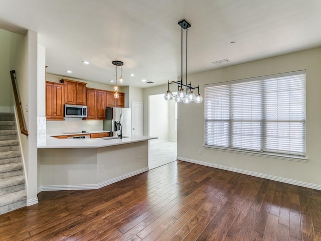 kitchen with dark hardwood / wood-style floors, stainless steel appliances, pendant lighting, and plenty of natural light