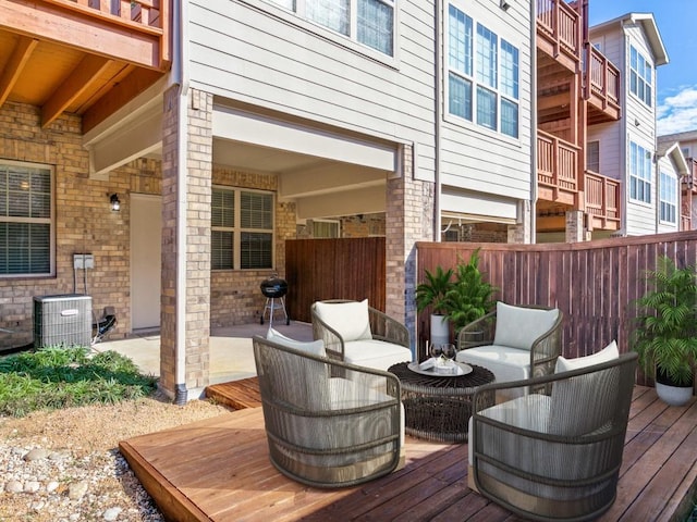 wooden terrace featuring an outdoor hangout area, cooling unit, and a patio