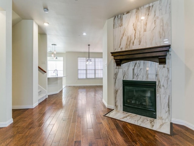 unfurnished living room featuring dark wood-type flooring and a premium fireplace